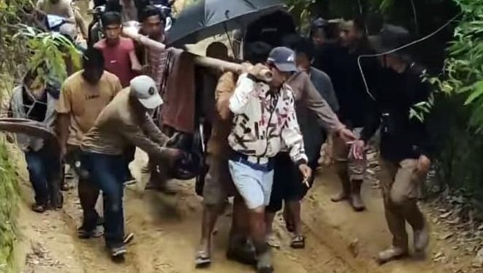 Bidan yang jatuh sakit di Polman ditandu warga karena akses jalan rusak.