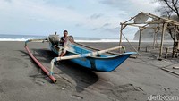 Para nelayan memindahkan perahu mereka ke tepi pantai agar tidak terbawa gelombang tinggi.