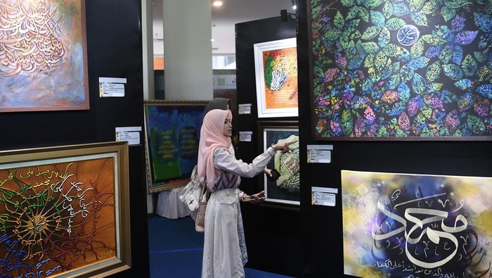 Pengunjung mengamati kaligrafi dalam Pameran Kaligrafi Internasional pada MTQ Nasional ke-30 Expo di Convention Hall, Gelora Kadrie Oening, Samarinda, Kalimantan Timur, Minggu (8/9/2024). Pameran yang diselenggarakan secara luring dan daring tersebut menampilkan sekitar 270 karya kaligrafi dari 71 seniman Indonesia dan 86 seniman dari 35 negara asing. ANTARA FOTO/M Risyal Hidayat/nym.