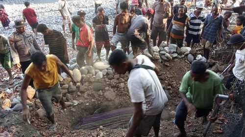 Polisi bersama warga saat mengubur 17 paus pilot mati terdampar di Pantai Pureman, Kabupaten Alor, NTT. (Dok. UPTD Pengelola Taman Perairan Kepulauan Alor dan Laut Sekitarnya)