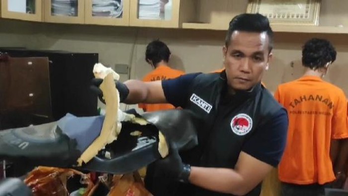 Polisi saat menunjukkan paket sparepart motor tempat pelaku menyembunyikan ganja. (Foto: Istimewa)