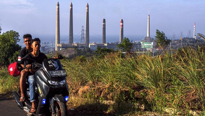Tinggi Emisi, 13 PLTU di Indonesia Bakal Ditutup Pengendara sepeda motor melintas di sekitar Pembangkit Listrik Tenaga Uap (PLTU) Suralaya, Cilegon, Banten, Minggu (8/9/2024). Kementerian Energi dan Sumber Daya Mineral (ESDM) berencana menghentikan operasional 13 unit PLTU di Indonesia termasuk di antaranya PLTU Suralaya, PLTU Paiton, dan PLTU Ombilin karena tingginya emisi yang dihasilkan. ANTARA FOTO/Angga Budhiyanto/gp/nym.