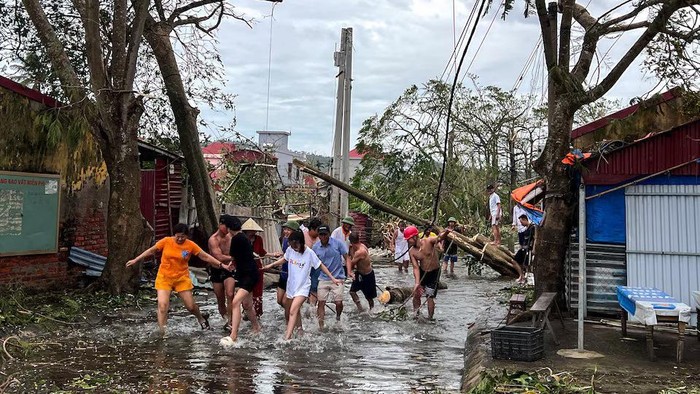 People use ropes to remove fallen trees following the impact of Typhoon Yagi, Hai Phong, Vietnam, September 8, 2024. REUTERS/Minh Nguyen Purchase Licensing Rights