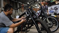 Dua pekerja menyelesaikan pembuatan sepeda listrik kustom di bengkel Strum, Jakarta, Senin (9/9/2024).