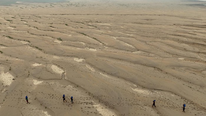 Darurat! Sungai Amazon Berubah Jadi Padang Pasir A drone view shows river dwellers carrying water gallons on the sandbanks of the Madeira river to bring to the isolated region of Paraizinho community, during the worst drought of the river in history, Humaita, Amazonas state, Brazil September 8, 2024. REUTERS/Bruno Kelly