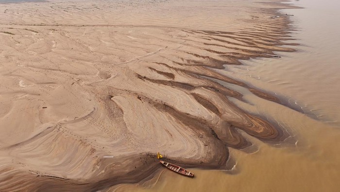 A drone view shows river dwellers carrying water gallons on the sandbanks of the Madeira river to bring to the isolated region of Paraizinho community, during the worst drought of the river in history, Humaita, Amazonas state, Brazil September 8, 2024. REUTERS/Bruno Kelly