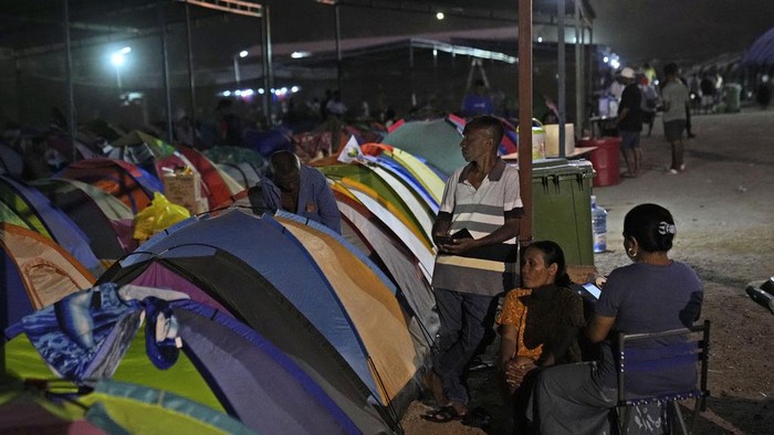 People who came from Oecusse, about 200 kilometers (124 miles) from the capital of Dili, sit near the tents where they camp while waiting to attend the holy mass presided by Pope Francis scheduled on Sept. 10, in Dili, East Timor, Sunday, Sept. 8, 2024. (AP Photo/Dita Alangkara)