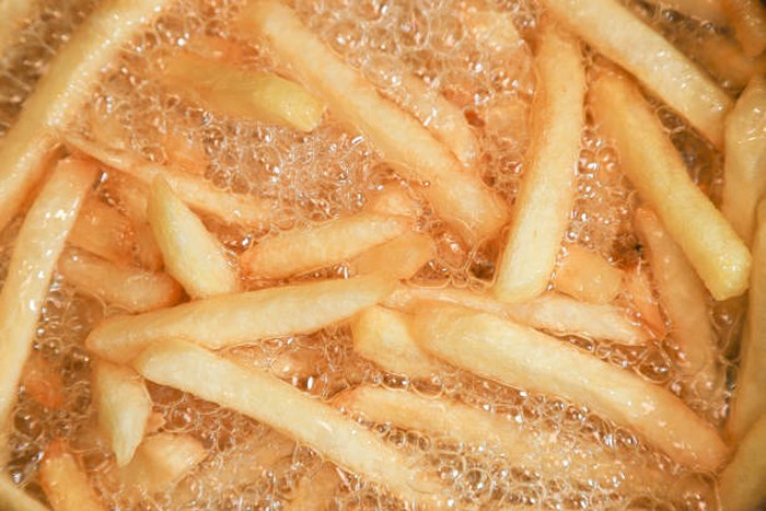 Close up of Frying french fries in the fryer in hot oil.