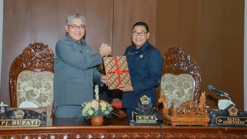 Ketua DPRD Gianyar Sementara Ketut Sudarsana dan Pj Bupati Gianyar I Dewa Tagel Wirasa bersalaman seusai meneken nota kesepakatan KUA-PPAS Perubahan 2024 dalam Sidang Paripurna di Ruang Sidang Utama Kantor DPRD Gianyar, Senin (9/9/2024). (Dok. Pemkab Gianyar)