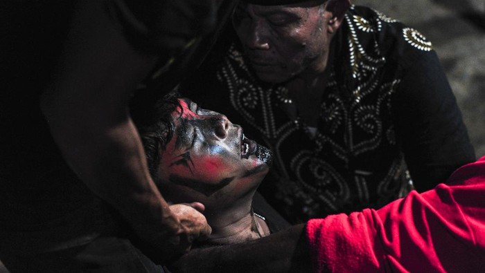 Pawang (atas) menenangkan salah seorang anggota Paguyuban Seni Budaya Suko Laras Kendali Bendung Sejati (SLKBS) yang kesurupan saat memainkan tari Kuda Lumping di permukiman transmigran Desa Tanjung Benanak, Tanjung Jabung Barat, Jambi, Senin (9/9/2024). Desa Tanjung Benanak yang merupakan salah satu desa transmigrasi yang dibuka pada tahun 90-an di kabupaten itu memiliki beberapa sanggar seni yang pendiriannya diinisiasi oleh beberapa keluarga transmigran setempat untuk mengenalkan seni tradisi leluhur mereka di daerah asal kepada anak-anak yang lahir dan besar di Jambi.  ANTARA FOTO/Wahdi Septiawan/tom.