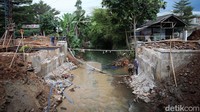 Selama proses perbaikan, warga bisa melintas di jembatan darurat.