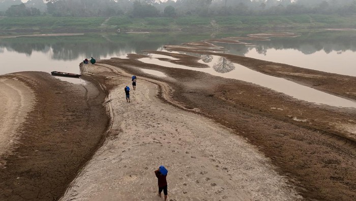 River dwellers fill a tank of water on the sandbanks of the Madeira river to bring to the isolated region of Paraizinho community, during the worst drought of the river in history, Humaita, Amazonas state, Brazil September 8, 2024. REUTERS/Bruno Kelly