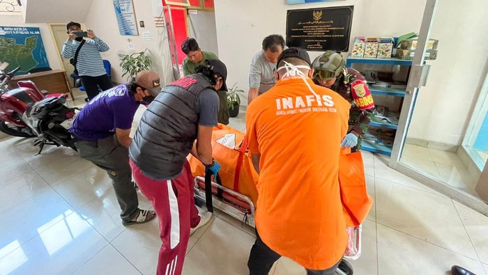 Polisi saat mengevakuasi jenazah petugas keamanan DP2KBP3A yang tewas di kantor