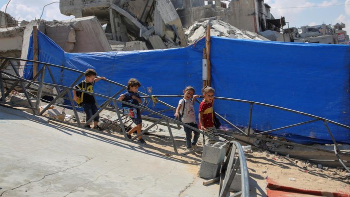 Palestinian teacher Israa Abu Mustafa gives a class to students inside a tent set up on the rubble of her house as war disrupts a new school year, amid the Israel-Hamas conflict, in Khan Younis, in the southern Gaza Strip, September 4, 2024. REUTERS/Hatem Khaled