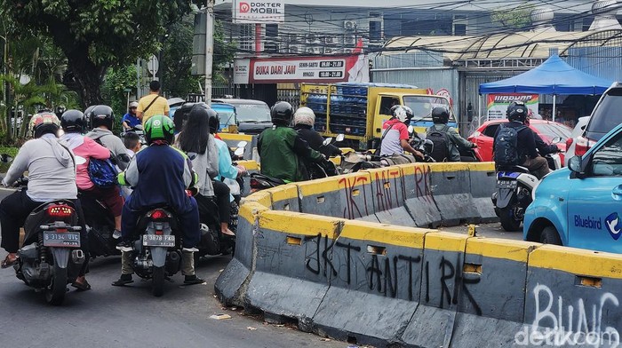 Pengendara melintas di samping tulisan 'JKT Anti Ridwan Kamil' dan JKT Anti RK', di Jl Bungur Besar, Jakarta, Selasa (10/9/2024). Tulisan liar tersebut berada di beton barrier tanpa keterangan siapa yang bertanggungjawab. Seperti diketahui, reaksi penolakan atas Ridwan Kamil mengemuka usai ia mendaftar sebagai pasangan calon Bersama Suswono dalam Pilgub Jakarta.