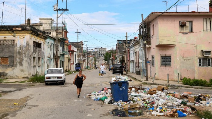 A man throws a bag on a pile of trash, as Cuban health authorities launched efforts to fight the spread of the Oropouche virus transmitted by mosquitoes and midges, but growing trash heaps combined with summer rains and limited resources are complicating those efforts, in Havana, Cuba August 31, 2024. REUTERS/Norlys Perez