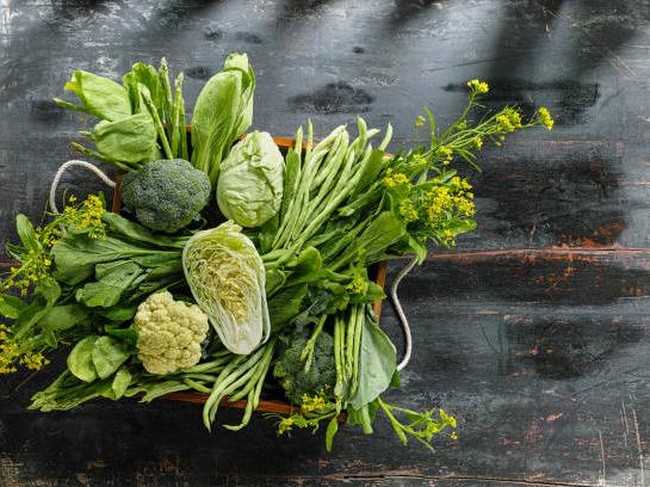 Ilustrasi sayuran berdaun hijau yang kaya akan kalsium. Market fresh green leaf vegetables in an old wooden crate on an old wooden table. Vegetables include, broccoli, cauliflower, cabbage, spring greens, bok choy, spinach and choy sum.