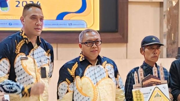 Komar (mengenakan Topi) sesaat setelah menerina hadiah umrah