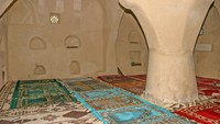 Bagian dalam masjid. Di bawahnya membentang karpet yang dilapisi dengan beberapa sajadah warna-warni. Di bagian dindingnya juga terdapat beberapa ceruk untuk menaruh Al-Quran. (Foto: iStock)