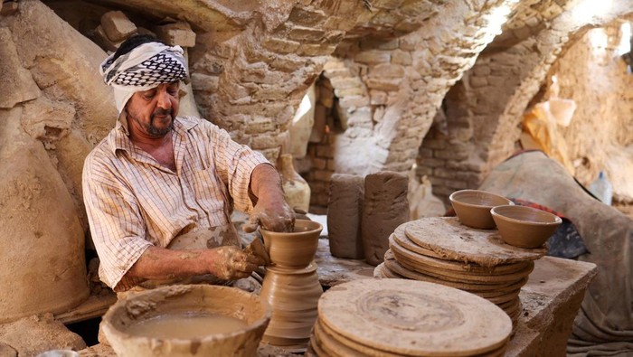 An Iraqi worker makes clay pots at a workshop in the holy city of Najaf, Iraq, September 9, 2024. REUTERS/Alaa Al-Marjani