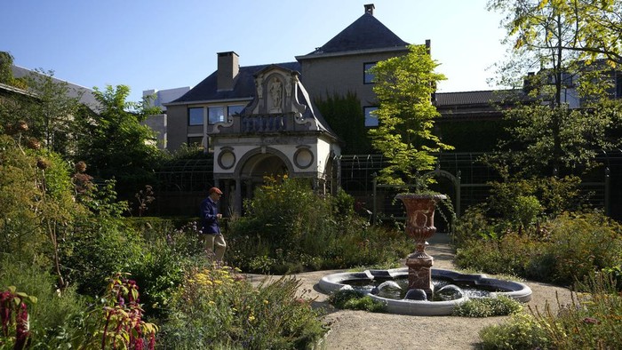 Mengintip Rumah Bersejarah Pelukis Paul Rubens di Antwerp A man walks by a fountain in the newly restored garden of the Rubens House in Antwerp, Belgium, Wednesday, Aug. 28, 2024. (AP Photo/Virginia Mayo)