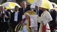 Uskup Agung Dili Kardinal Virgilio do Carmo da Silva, melindungi Paus Fransiskus dari terik matahari dengan payung berwarna bendera Vatikan.