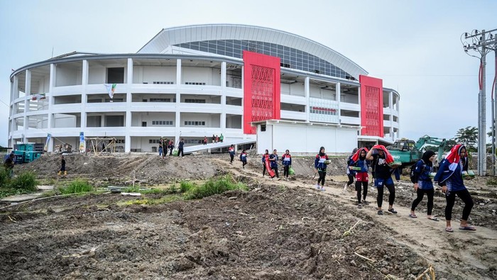 Pengunjung PON XXI Aceh-Sumut melewati jalan berlumpur di GOR Bola Voli Indoor Sumut Sport Center, Kabupaten Deli Serdang, Sumatera Utara, Selasa (10/9/2024). Pertandingan voli indoor yang semula dijadwalkan Selasa (10/9) diundur menjadi Rabu (11/9) karena GOR belum siap dan akses jalan berlumpur. ANTARA FOTO/Rivan Awal Lingga/nz