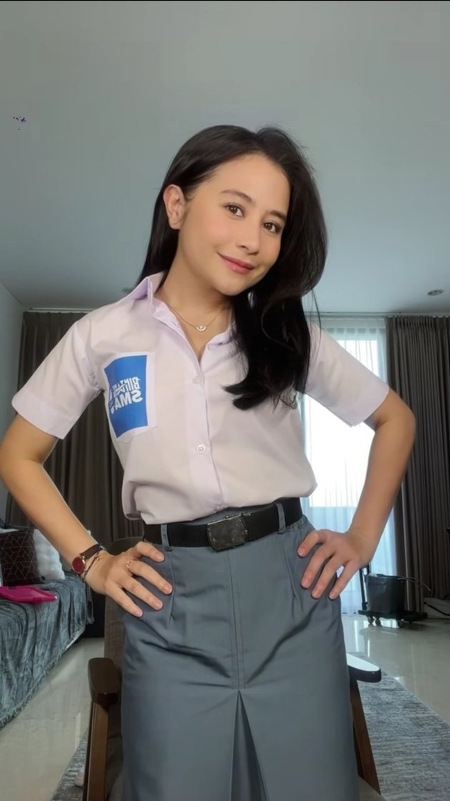 Rok abu-abu panjang tampak dipadukannya dengan kemeja putih dengan kancing atas yang dibuka 2. Melengkapi penampilannya, Prilly juga mengenakan beberapa perhiasan simpel, seperti anting, kalung, gelang, dan jam tangan. Foto: Instagram/@prillylatuconsina96