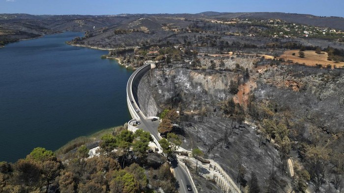 The blackened forests around Marathon Lake, which had been burned in a mid-August wildfire, are seen from above about 36 kilometres (22 miles) north of Athens, Thursday, Aug. 22, 2024. (AP Photo/Thanassis Stavrakis)