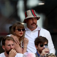 Sementara itu, Travis mengenakan kardigan putih bergaris merah dan hijau serta celana pendek senada. Bintang Kansas City Chiefs itu memadukan pakaiannya dengan kemeja polo putih dan topi bucket Gucci cokelat, yang juga bergaris hijau dan merah. (Foto: Al Bello/Getty Images)