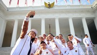 Para atlet swafoto dengan latar belakang Istana Merdeka.  
