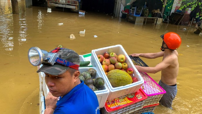 Banjir gegara Topan Yagi Masih Rendam Vietnam A woman holds a boy as she wades through a flooded street following the impact of Typhoon Yagi, in Thai Nguyen City, Vietnam, September 11, 2024. REUTERS/Thinh Nguyen