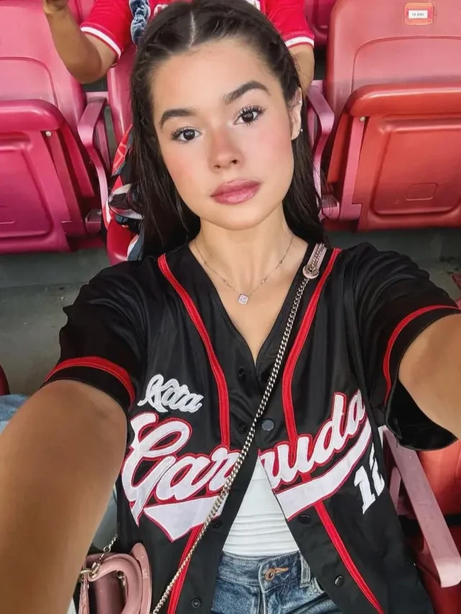 Maria Theodore mengenakan atasan hitam model jersey baseball dengan tulisan Kita Garuda dipadukan inner putih dan celana denimnya. (Foto: Instagram)