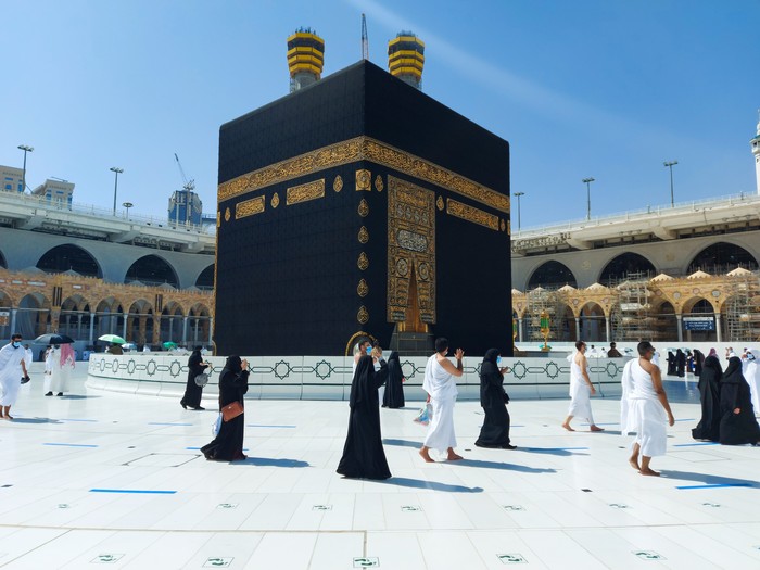 MECCA, SAUDI ARABIA , OCTOBER 22, 2020 - Pilgrims circle the Kaaba in Masjid al-Haram - umrah Fewer Muslims people Socially Distanced corona virus wearing face mask