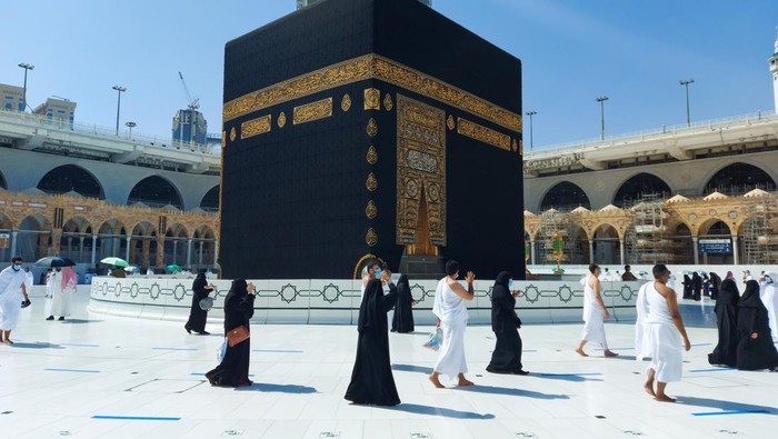 MECCA, SAUDI ARABIA , OCTOBER 22, 2020 - Pilgrims circle the Kaaba in Masjid al-Haram - umrah Fewer Muslims people Socially Distanced corona virus wearing face mask