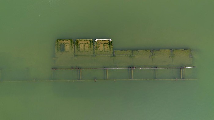 Kapal Perang Nazi yang Dulu Tenggelam, Kini Muncul Lagi ke Permukaan A drone image shows a sunken German warship from World War II, exposed due to low Danube river levels caused by drought and extreme heat, in Prahovo, Serbia, September 5, 2024. REUTERS/Djordje Kojadinovic
