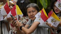 Kerumunan orang yang melambaikan bendera Vatikan dan bendera Singapura juga turut menyambut kedatangan Paus Fransiskus di Bandara Changi.