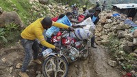 Para warga bergotong royong untuk membantu taksi sepeda motor yang terjatuh akibat kehilangan kendali saat melintasi gunung karena bawaannya yang cukup banyak.