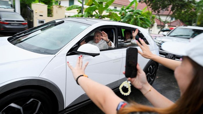 Potret Paus Fransiskus Naik Mobil Listrik di Singapura People line the road to catch a glimpse of Pope Francis as he arrives, during the last leg of his apostolic visit to Asia, in Singapore, September 11, 2024. REUTERS/Caroline Chia