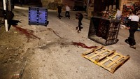 Warga setempat meninjau lokasi serangan udara Israel yang menewaskan warga Palestina. Sisa-sisa serangan terlihat di jalanan dengan bekas darah dan puing-puing yang berserakan.  