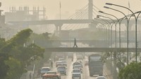 Orang-orang menyeberangi jembatan penyeberangan di tengah asap yang disebabkan oleh kebakaran hutan, di Cochabamba, Bolivia, Selasa (10/9/2024).  