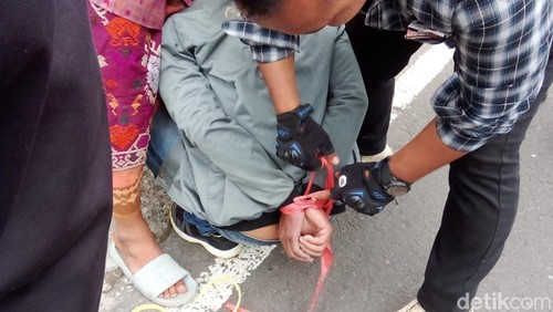 Warga Desa Dapdap Putih, Kecamatan Busungbiu, Buleleng, Bali menangkap seorang pria yang diduga melakukan hipnotis, Rabu (11/9/2024). (Tangkapan layar video viral)