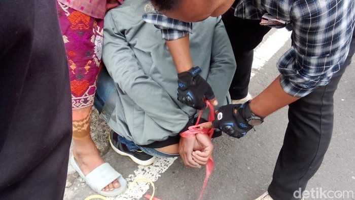 Warga Desa Dapdap Putih, Kecamatan Busungbiu, Buleleng, Bali menangkap seorang pria yang diduga melakukan hipnotis, Rabu (11/9/2024). (Tangkapan layar video viral)