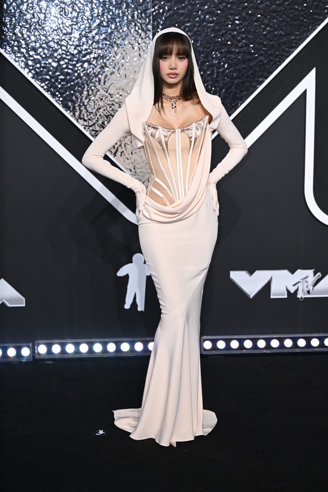 Kehadiran Lisa menuai sorotan sejak tampil di karpet merah. Wanita itu pun hadir dengan gaun unik berpotongan mermaid. Meski memilih warna krem yang tidak mencolok, busana tersebut punya detail draperi dan hoodie sekaligus sarung tangan yang membuatnya menarik. Pelantun ‘Money’ itu pun memadukannya dengan kalung ‘ular’.Foto: PA Images via Getty Images/Doug Peters - PA Images