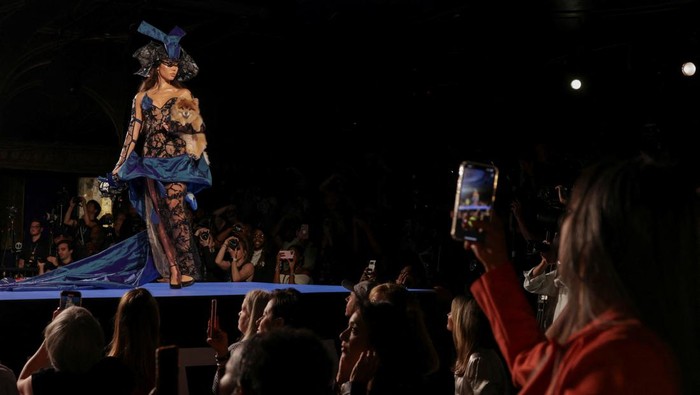 A model carries a dog to present creations during the Catwalk Furbaby Fashion Show at New York Fashion Week, in New York City, U.S., September 5, 2024. REUTERS/Kent J Edwards