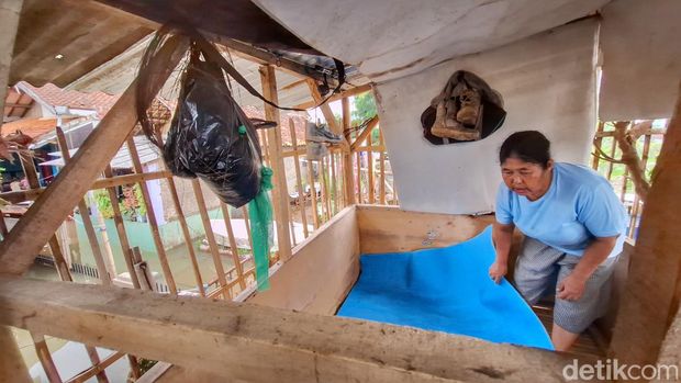 Ayun Yuningsih (50), tengah membereskan karpet yang berada di saung dekat Kandang Ayam, Kampung Cijagra, Kecamatan Bojongsoang, Kabupaten Bandung, Kamis (11/9/2024).