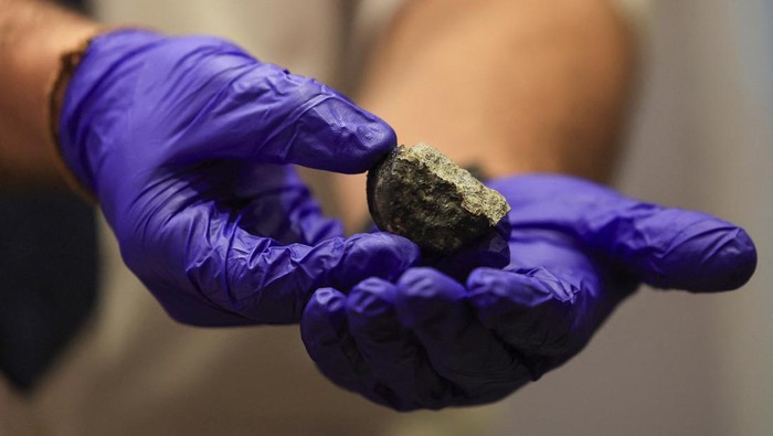 Batu Meteor Langka Ditemukan di Afrika Selatan, Ini Potretnya A researcher handles a fragment of meteorite during a press conference where researchers from the University of the Witwatersrand, Nelson Mandela University and Rhodes University explain the entry of a meteorite into Earth's atmosphere over South Africa last week, in Gqeberha, South Africa, September 3, 2024. REUTERS/Esa Alexander