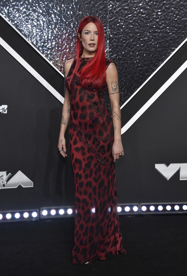 Fire in red. Tren gaun vintage juga dibawa oleh Halsey. Ia memakai gaun merah Versace yang pernah dipakai Elizabeth Hurley pada 1996.  (Foto: Evan Agostini/Invision/AP)