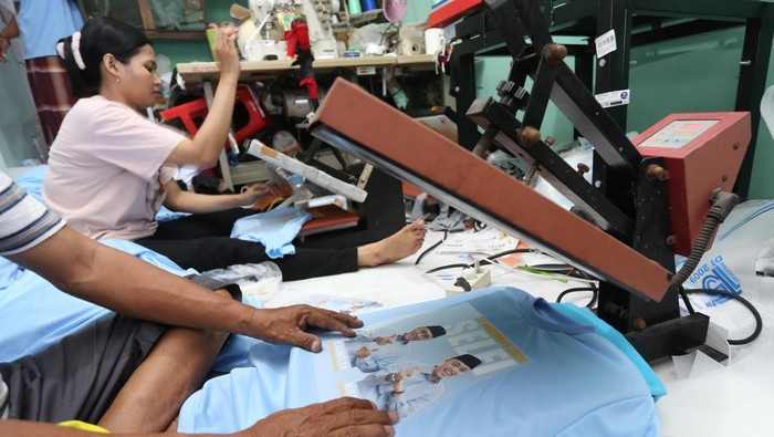 Pekerja menyablon kaos bergambar salah satu pasangan calon peserta Pilkada 2024 di Konveksi 99 SUB di Surabaya, Jawa Timur, Kamis (12/9/2024). Menjelang Pilkada 2024 pesanan sablon kaos di tempat tersebut meningkat hingga lima kali lipat dari rata-rata 200 lembar perhari menjadi 1.000 lembar perhari. ANTARA FOTO/Moch Asim/YU