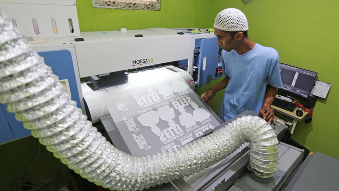 Pekerja menyablon kaos bergambar salah satu pasangan calon peserta Pilkada 2024 di Konveksi 99 SUB di Surabaya, Jawa Timur, Kamis (12/9/2024). Menjelang Pilkada 2024 pesanan sablon kaos di tempat tersebut meningkat hingga lima kali lipat dari rata-rata 200 lembar perhari menjadi 1.000 lembar perhari. ANTARA FOTO/Moch Asim/YU